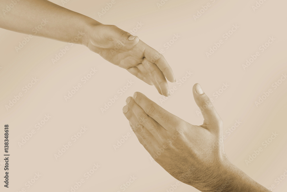 Male and female hands on light background, toned in sepia