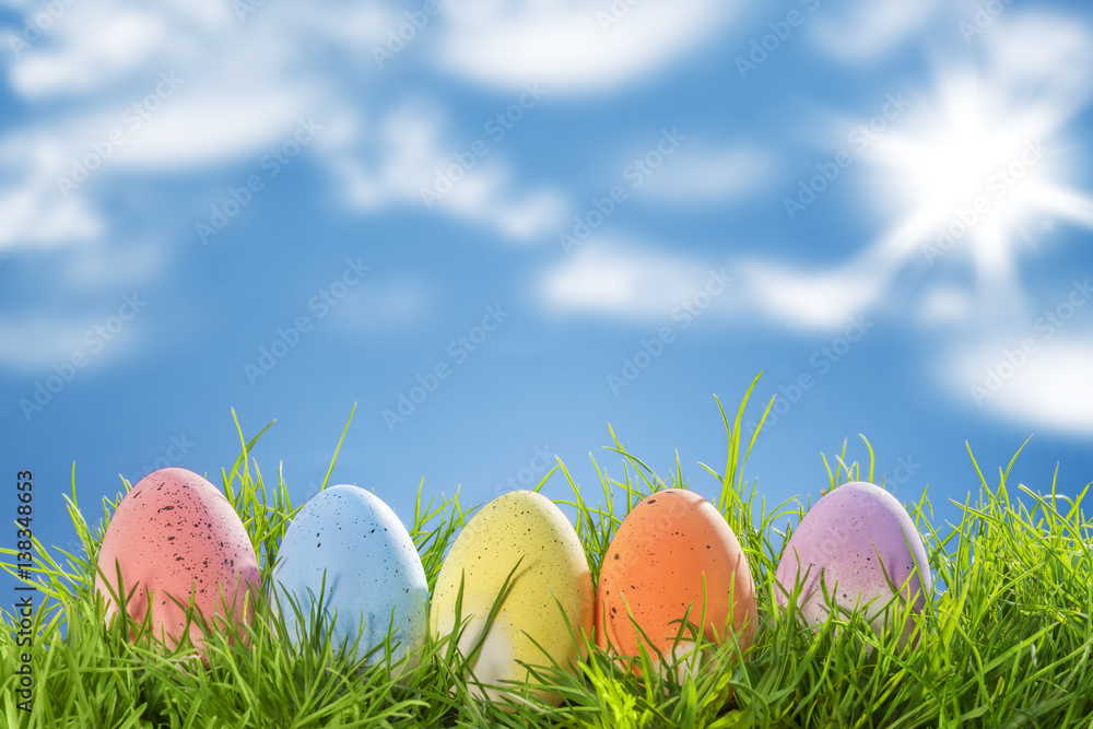 Easter eggs, on grass, blue sky background Easter eggs, on grass, blue sky background