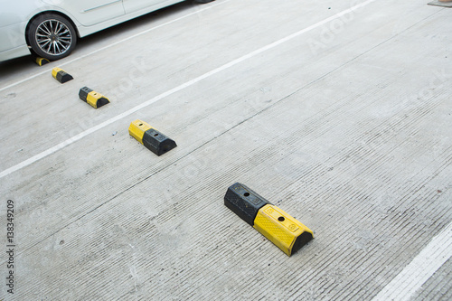 Concrete for cars brake with yellow traffic lines in car parking area