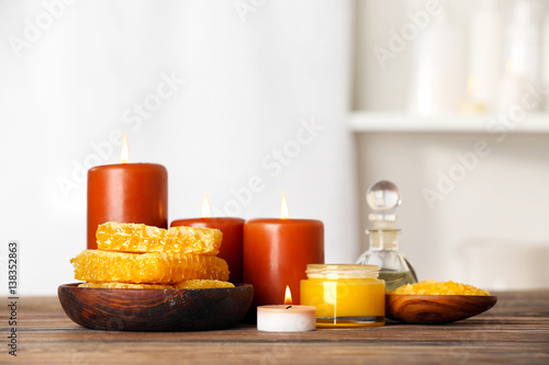 Spa concept. Honey treatments, candles and aroma oil on wooden table