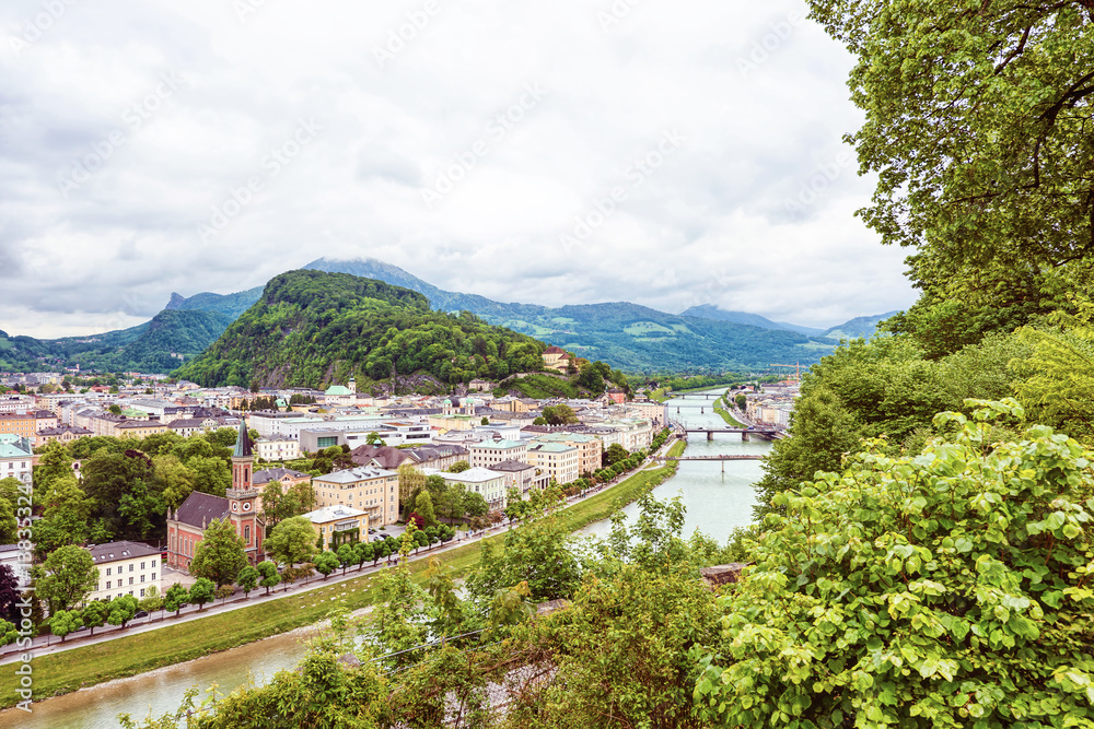 Panoramic view over stadt salzburg with salzach river, rainy day, bridge and mountains, austria
