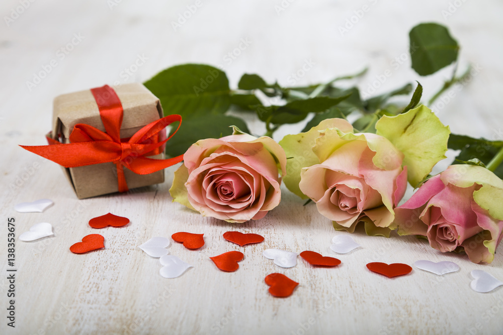 Pink roses, gift and hearts on a wooden background. Pink roses, gift and hearts on a wooden background.
