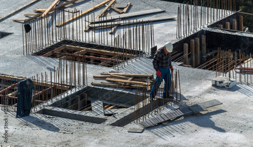 Construction worker wearing helmet working on the top of the building