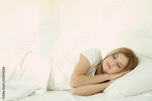 Young attractive woman sleeping in bed at home