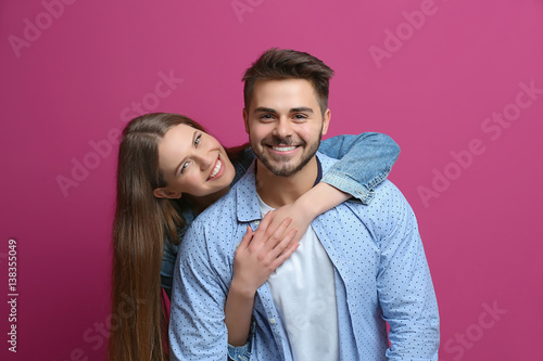 Cute young couple on color ...