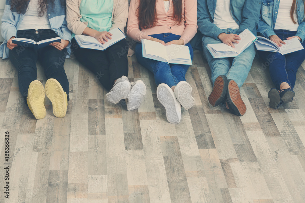 Fototapeta premium Group of people reading books while sitting on floor