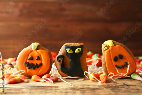 Halloween cookies and jelly sweets on wooden background photo