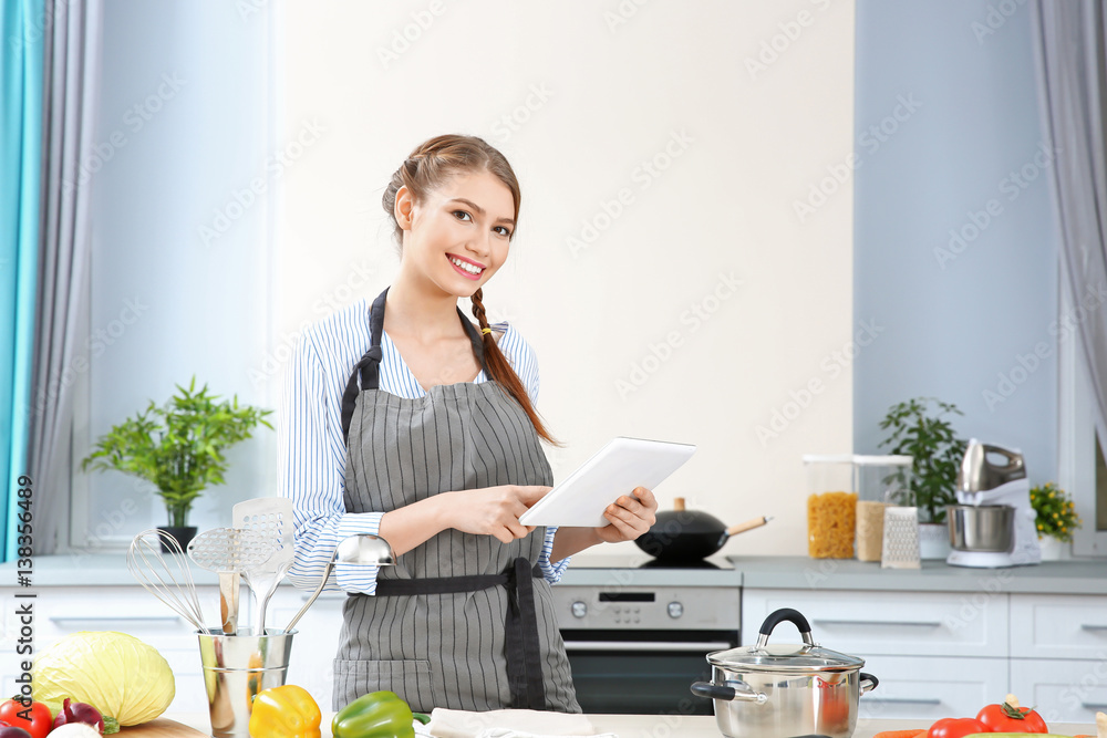 Young woman using tablet for searching recipe in internet Young woman using tablet for searching recipe in internet
