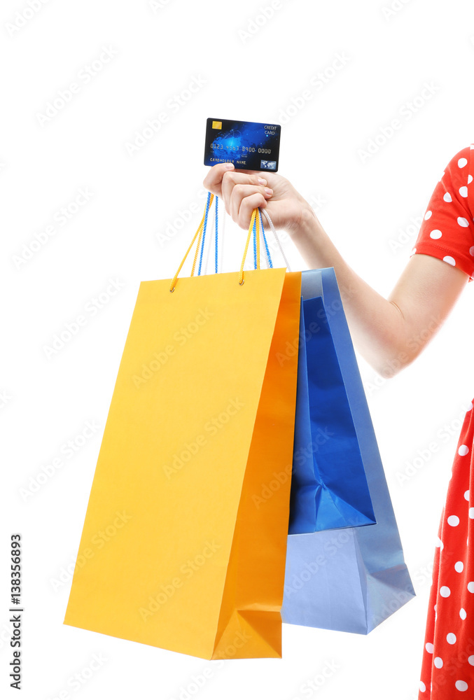 Woman holding shopping bags and credit card on white background