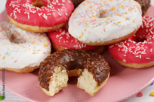 Tasty glazed donuts on plate, closeup