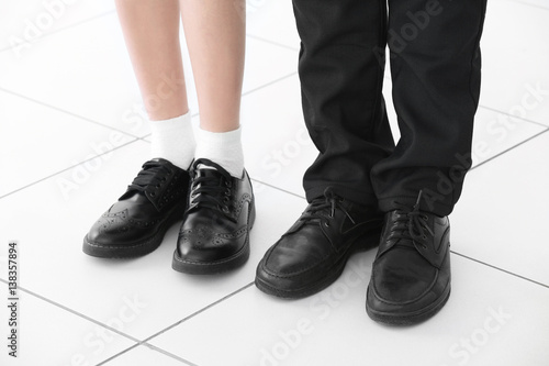Legs of girl and boy on tiled floor background