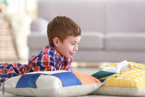 Little boy reading book on ...