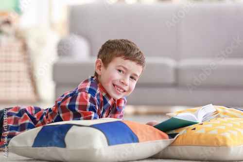 Little boy reading book on ...