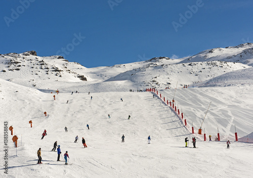 Fotografija Skiers on a piste in alpine ski resort
