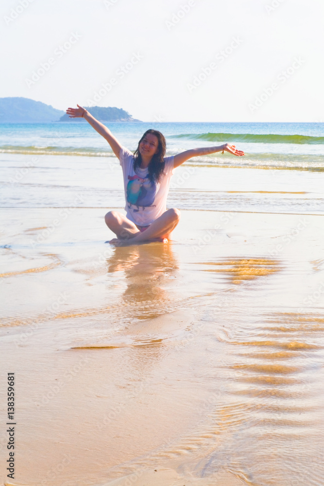Girl sitting on the sand by the ocean. Girl sitting on the sand by the ocean.