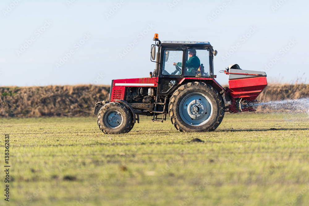 Obraz premium Tractor spreading artificial fertilizers