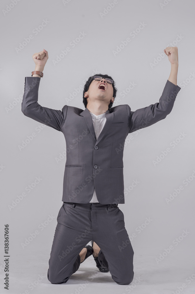 Young handsome business man in gray suit and glasses feel success with gray background Young handsome business man in gray suit and glasses feel success with gray background
