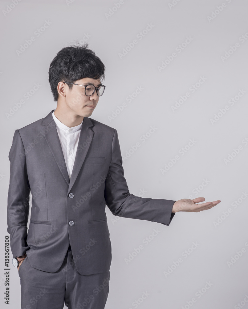 Young handsome business man in gray suit and glasses feel success with gray background Young handsome business man in gray suit and glasses feel success with gray background