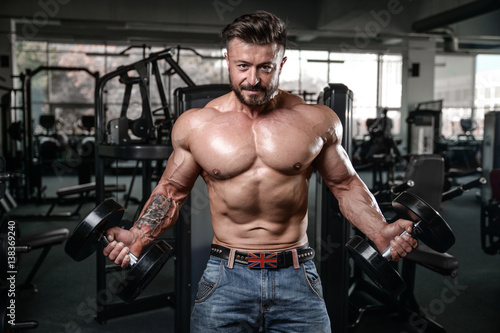 Brutal strong bodybuilder man pumping up muscles and train gym © antondotsenko