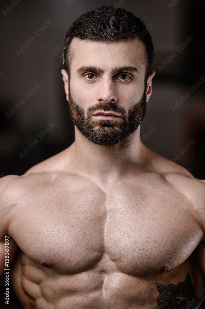 Obraz premium Handsome fitness model train in the gym gain muscle.