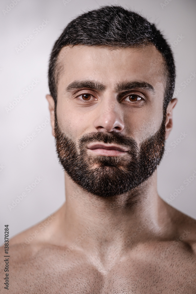 Fototapeta premium Brutal strong bodybuilder man posing in studio on grey background.