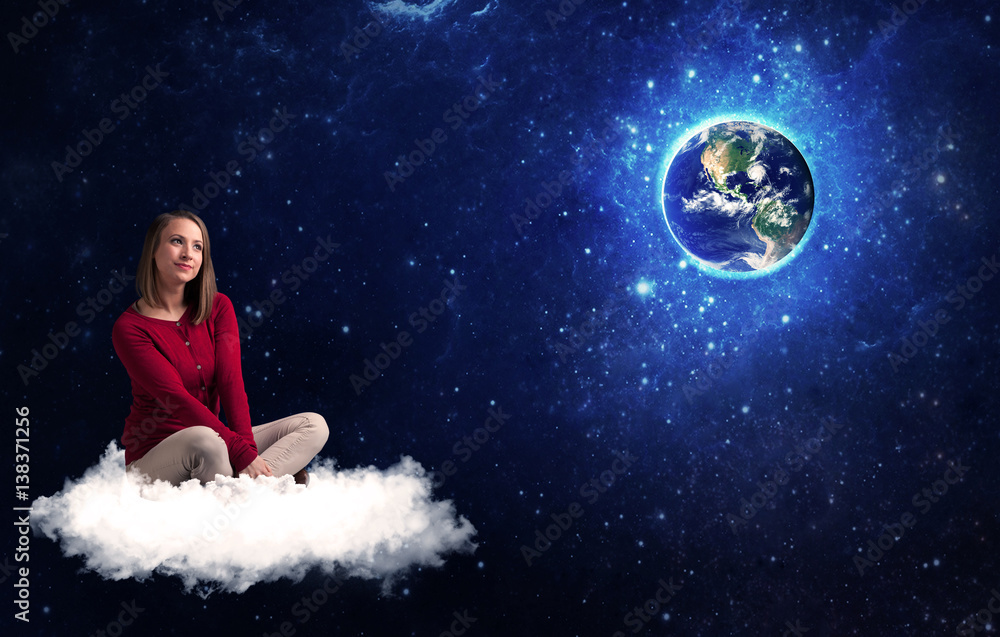 Woman sitting on cloud looking at planet earth Woman sitting on cloud looking at planet earth