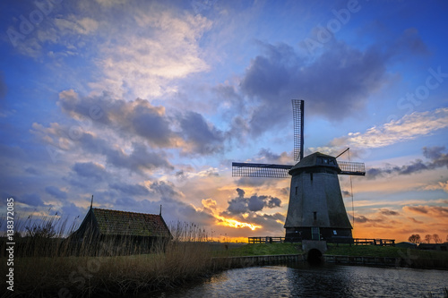 Water mill beside an Eilandspolder canal in sunset, the Netherlands photo