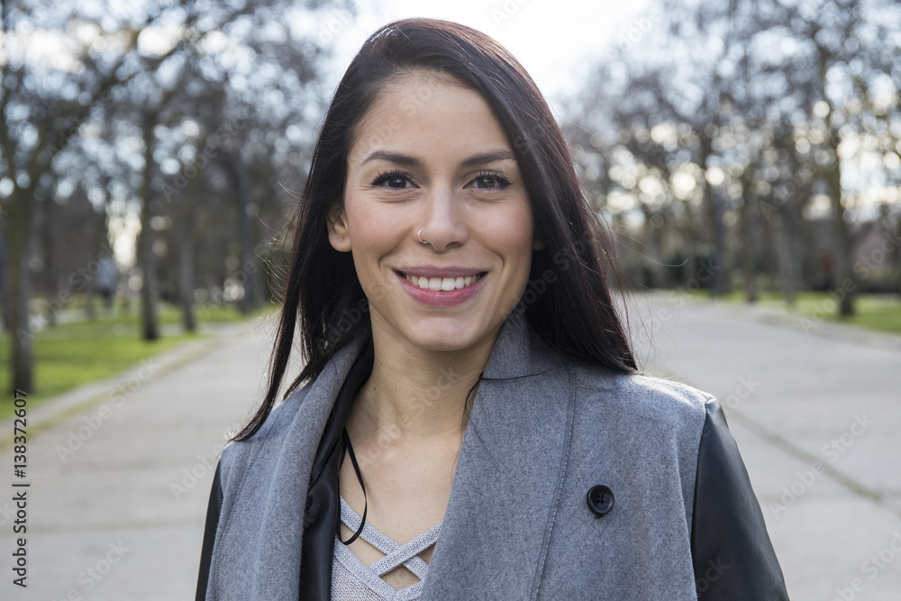 Portrait of smiling young woman with nose piercing in a park Portrait of smiling young woman with nose piercing in a park
