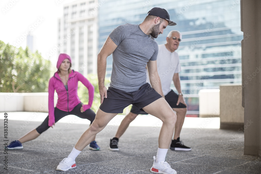 Three athletes stretching in the city Three athletes stretching in the city