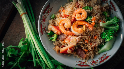 Vintage style Thai traditional food fried rice with shrimp on top and wooden background wallpaper