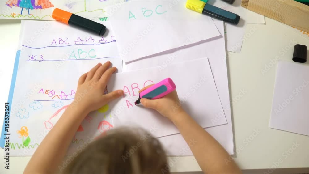 Happy family. Mother and daughter are learning to write. Adult woman teaches child the alphabet. Dolly shot. Happy family. Mother and daughter are learning to write. Adult woman teaches child the alphabet. Dolly shot.