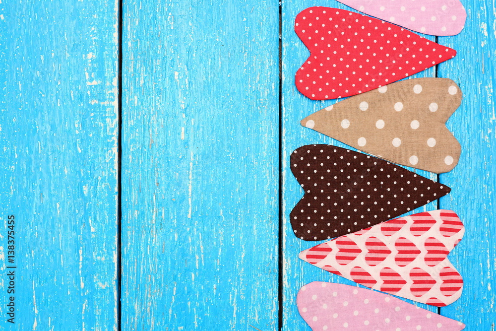 Obraz premium Colorful handmade hearts from fabric on background of blue boards. Love and romance. Feelings