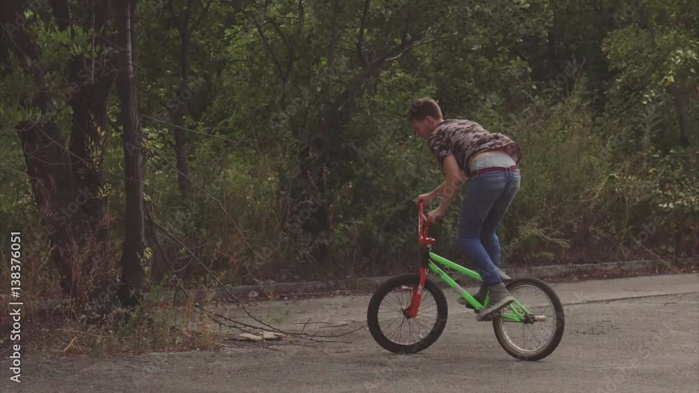 The guy quickly enters the BMX bike on the trampoline, and then removed his hands from the steering wheel, showing their professionalism. A man riding in the summer skate park. The guy quickly enters the BMX bike on the trampoline, and then removed his hands from the steering wheel, showing their professionalism. A man riding in the summer skate park.