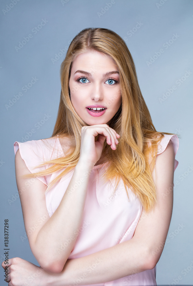 Portrait d'une jeune femme surprise , une main sous le menton Portrait d'une jeune femme surprise , une main sous le menton