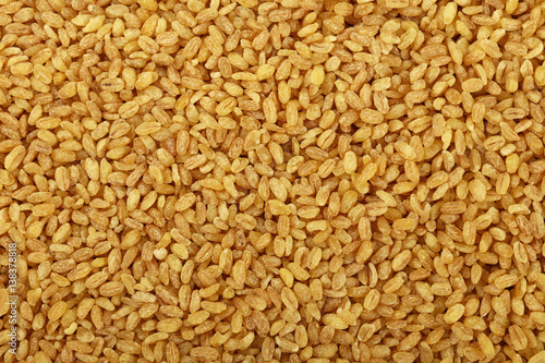 Yellow bulgur big grains close up background photo