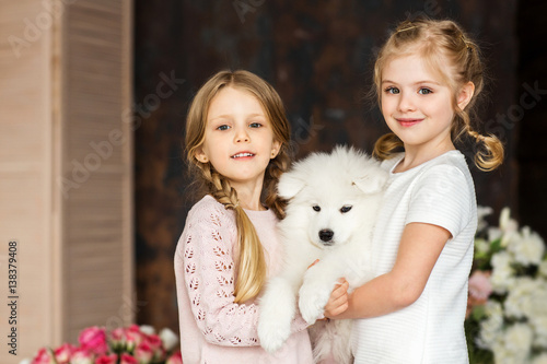 Little girls with a samoyed puppy © Natalia Chircova