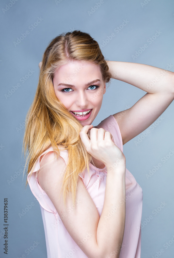 Portrait d'une jeune femme souriante, un bras derrière la tête Portrait d'une jeune femme souriante, un bras derrière la tête