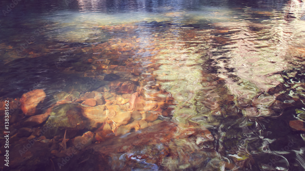 Clear river water with rocks, brown background & nature lighting