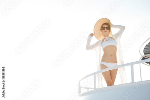 Gorgeous woman wearing hat posing on the yacht