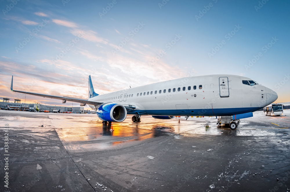 Airplane parked at the airport at the sun dawn sky