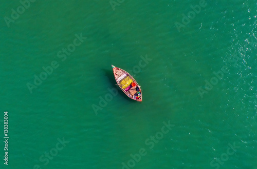 Fishing boat floating in the sea. The beautiful bright blue water in a clear day.Aerial view.Top view. photo