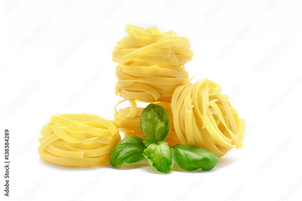 Fettuccine pasta with basil on white background Fettuccine pasta with basil on white background