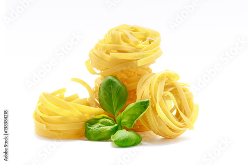 Fettuccine italian pasta with basil isolated on white background