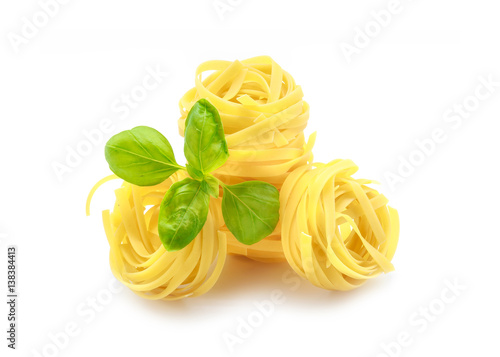 Fettuccine pasta with basil on white background