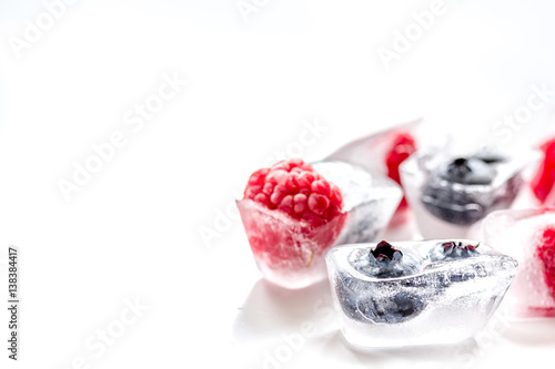 fresh blueberry and raspberry in ice on table background mock-up