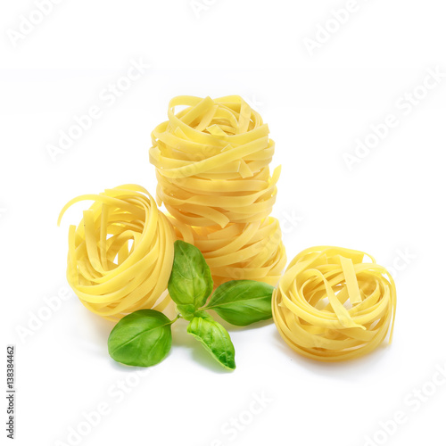 Tagliatelle pasta with basil isolated on white background