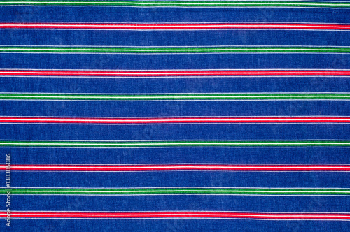Batiste fabric texture. striped coloring, red green blue white stripes