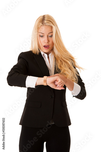 Portrait of shocked young woman holding hand with wrist watch and looking at camera isolated on a white background