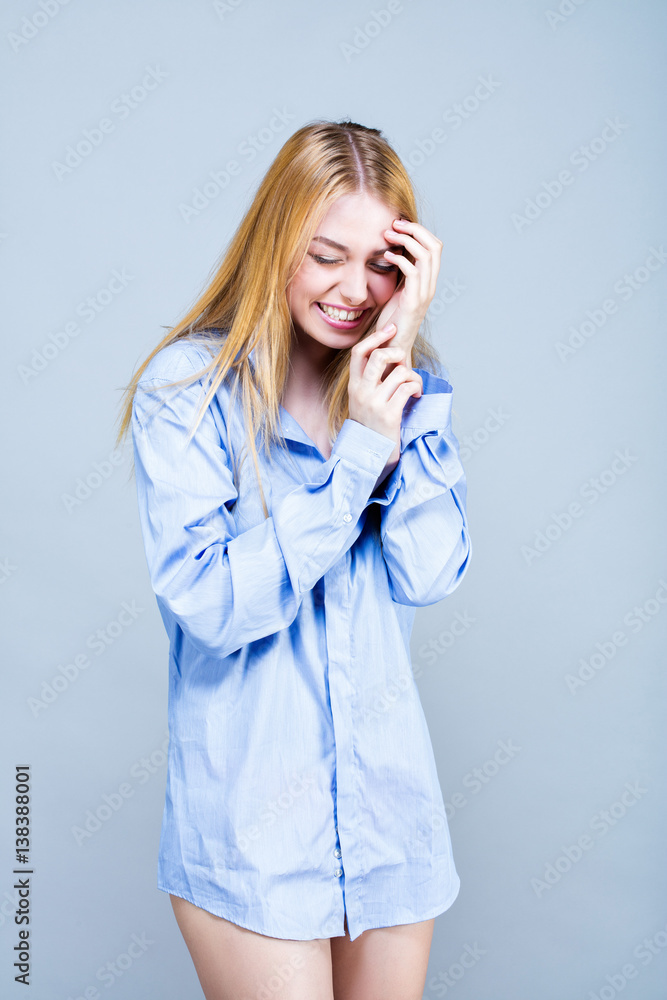 Portrait d'une jeune femme souriante, en chemise , une main sur le front, les yeux fermés Portrait d'une jeune femme souriante, en chemise , une main sur le front, les yeux fermés
