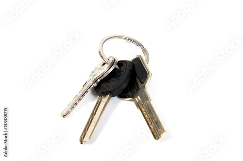 details of key ring with various door and car keys against a white background © allaordatiy